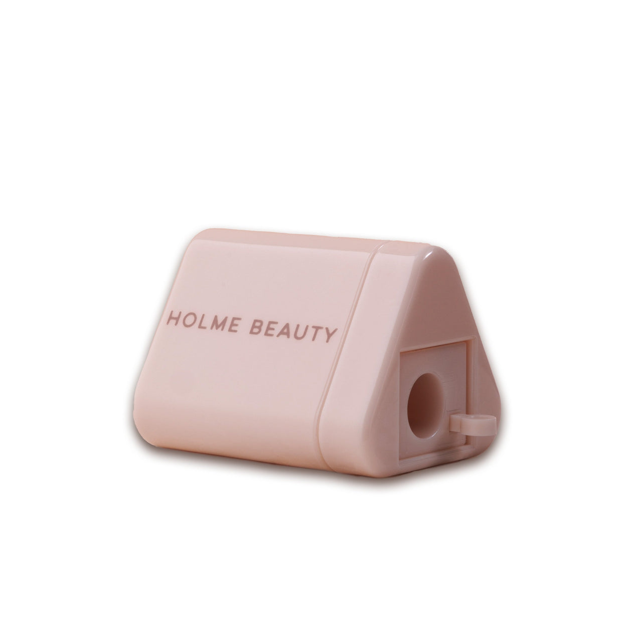 A pink ergonomic pencil sharpener with a triangular container and the brand 'HOLME BEAUTY' printed on the side.
