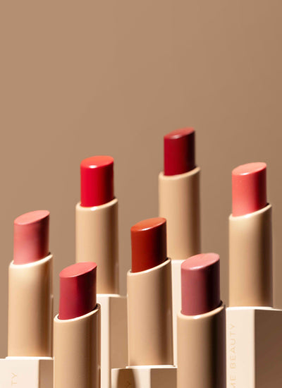 Set of lipsticks in various shades on a beige background
